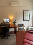 The chiropractic treatment room at Brunswick Health, with a treatment table, desk and spine chart