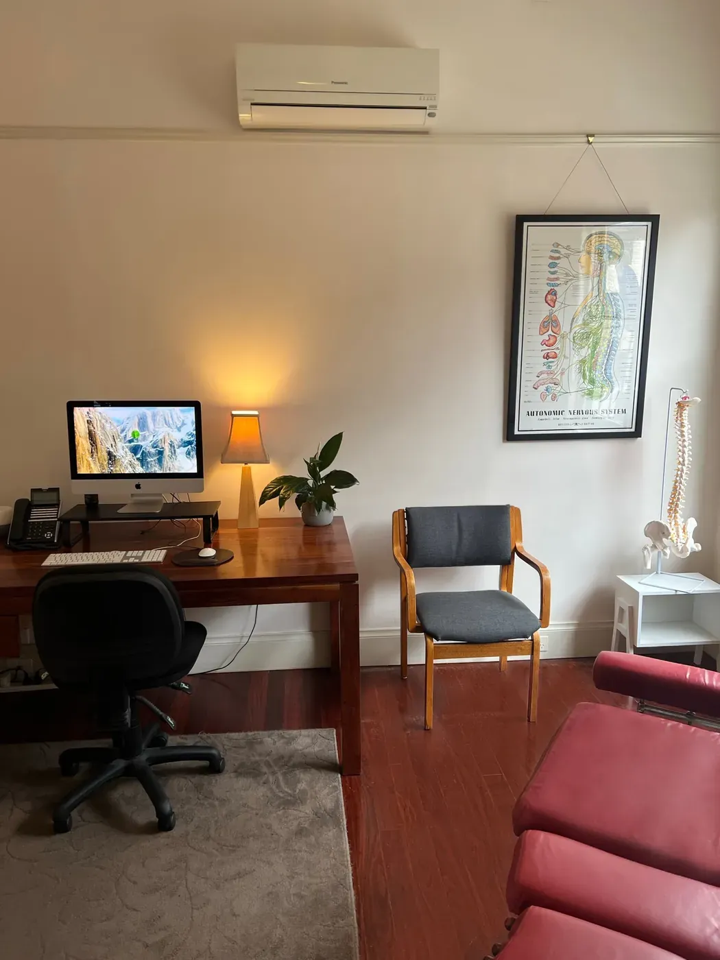 A chiropractic treatment room with two adjusting tables and an original fireplace