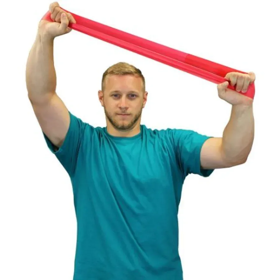 A man holding a red band loop overhead, stretching it apart between both hands