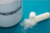 An open probiotic capsule and its powder beside a probiotic jar
