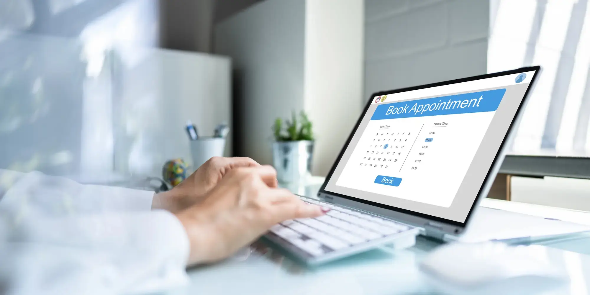 Someone booking an appointment on a laptop, with a booking calendar open on the screen