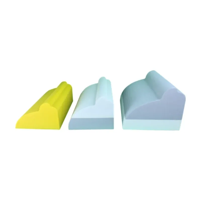 The three lumbar Denneroll sizes side by side: the small in solid gold, the medium with a white top and the large with a grey top, each a wedge with a raised ridge
