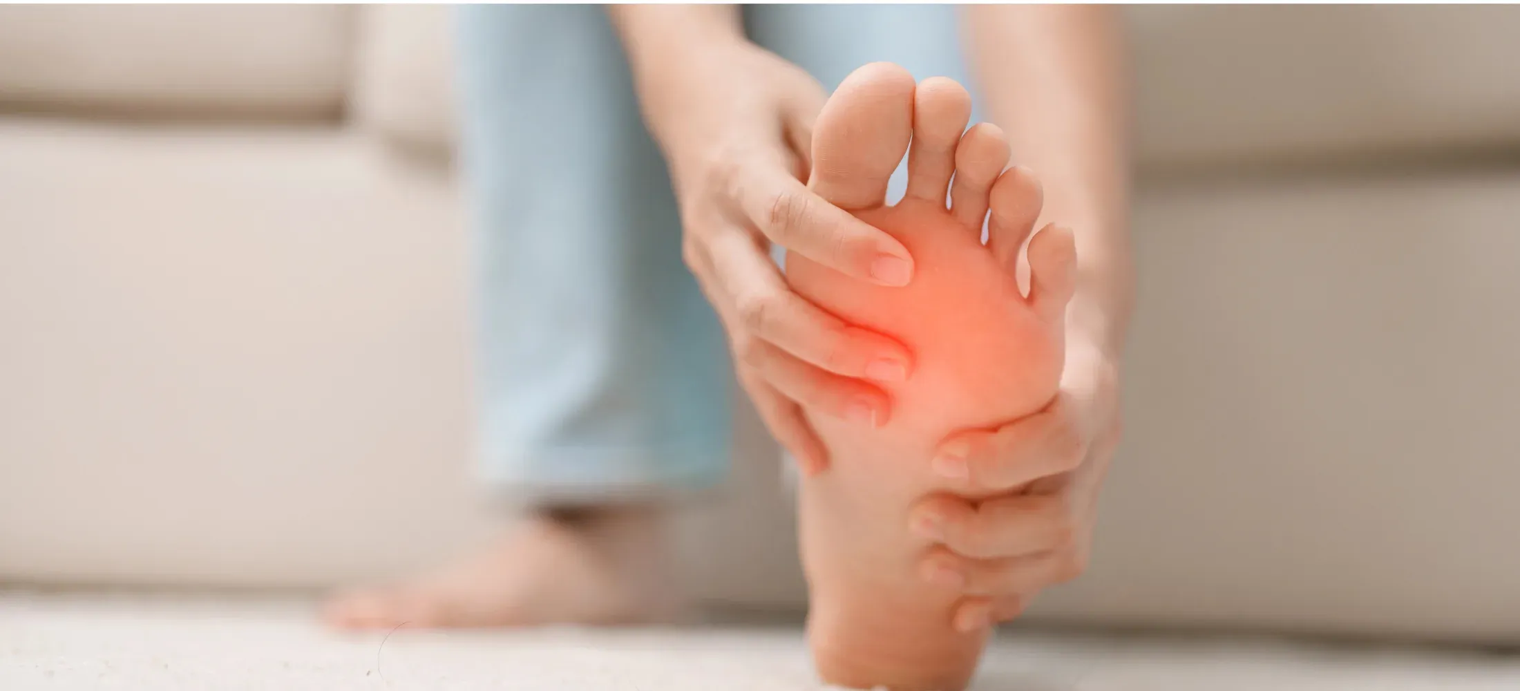 A person pressing into the ball of their own foot, the forefoot reddened