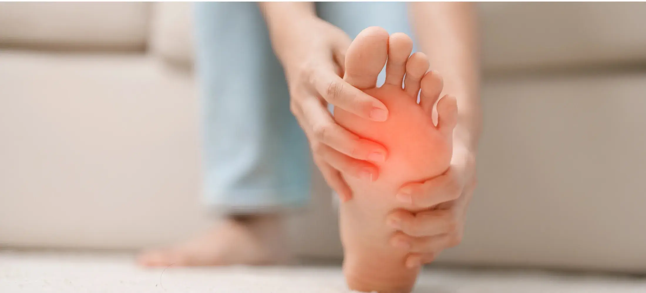 A person pressing into the ball of their own foot, the forefoot reddened