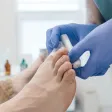 Gloved hands applying a dressing to a patient's big toe