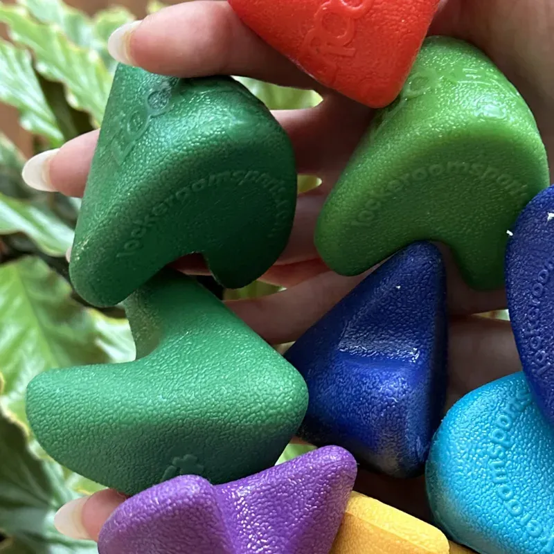 A handful of Lockeroom Pocket Physio trigger point tools in red, green, blue, light blue, purple and yellow