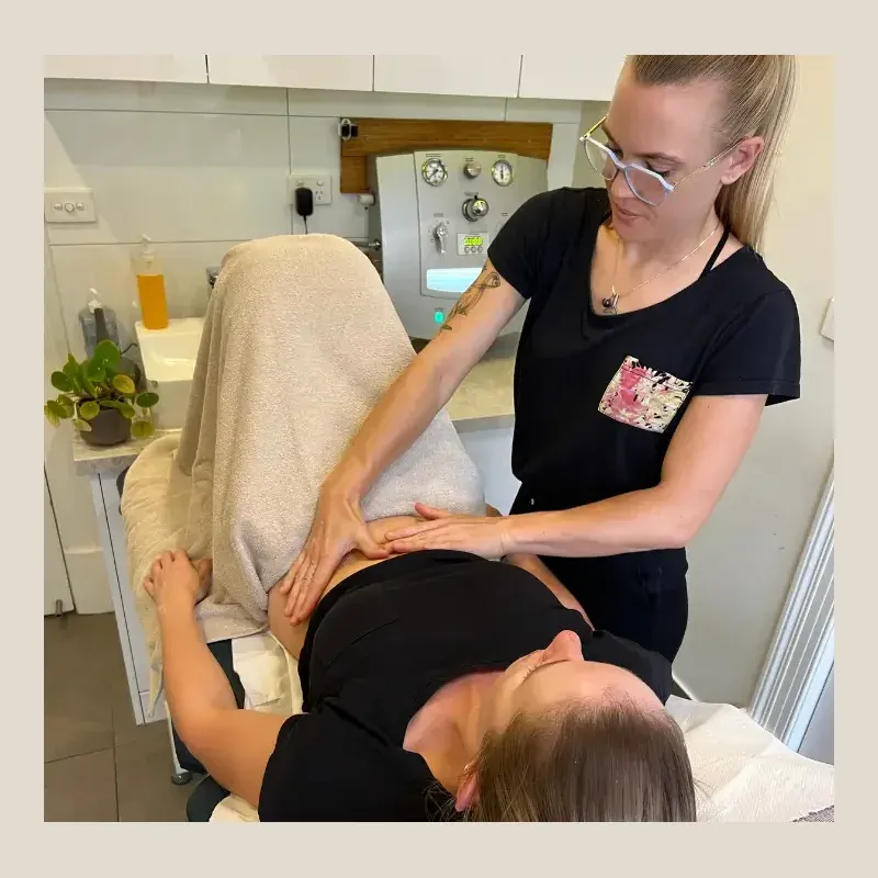 The therapist working over a patient's abdomen during a session