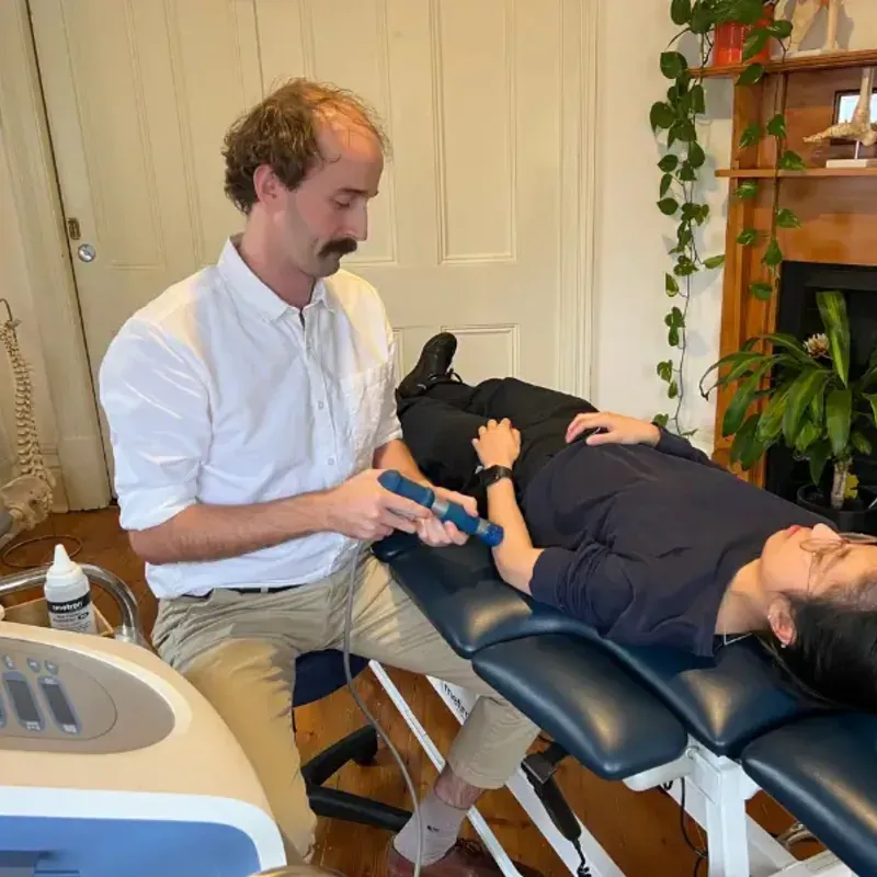 Physiotherapist Andrew Macdonald applying shockwave therapy to a patient's forearm