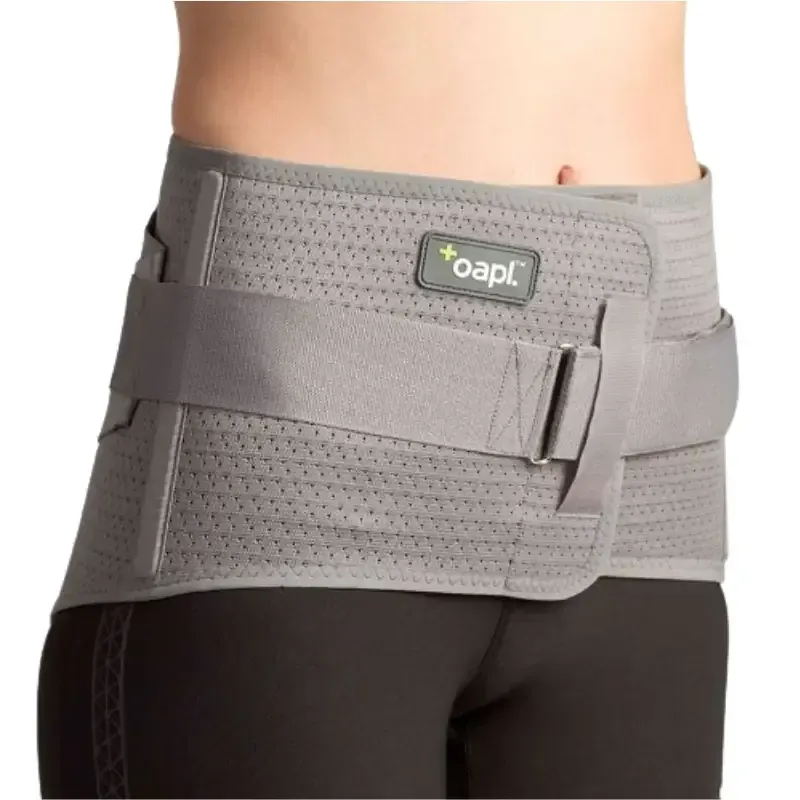 A grey sacro cinch low back support belt worn around the hips
