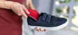 An orthotic insole being placed into a shoe