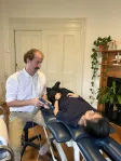 A shockwave therapy handpiece applied to a patient's lower leg