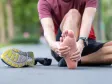 A person holding the underside of their heel