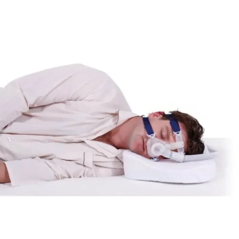 A man sleeping in a CPAP mask on a CPAP-compatible pillow