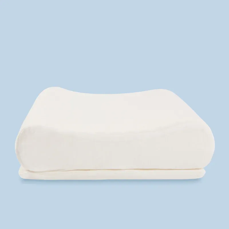 The pillow square-on from the side, showing the two contour heights and the removable layer beneath