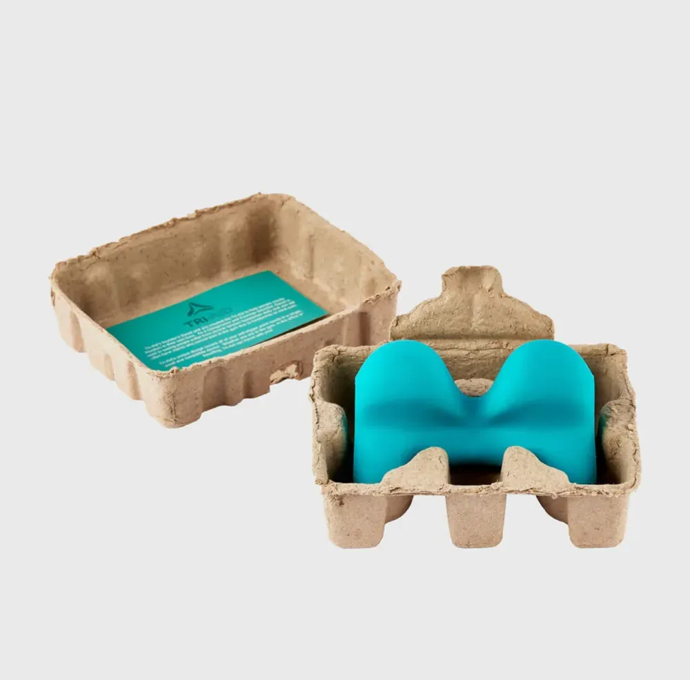 The device beside its moulded recycled-paper packaging