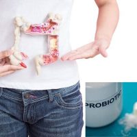 Person holding a model of the human digestive system, representing colonic irrigation with probiotic Infusions