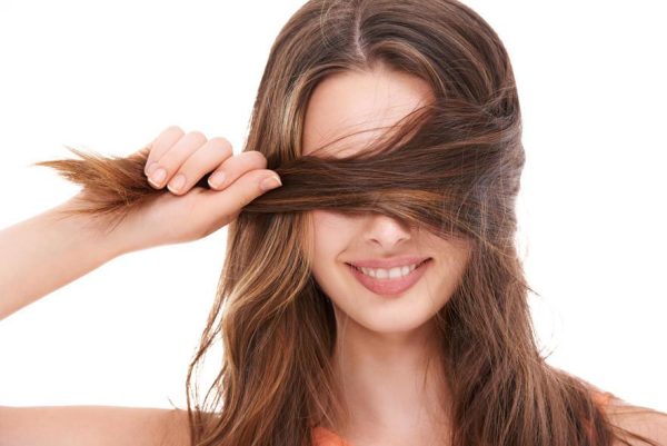 woman holding strands of brown hair, representing hair mineral and toxic element testing