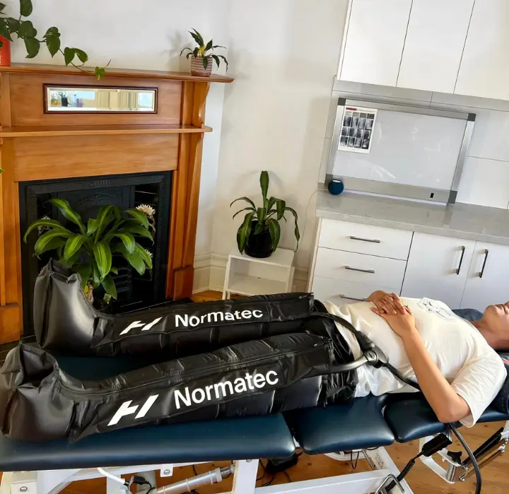 A physiotherapy clinic room in Melbourne with a treatment table and decompression Normatec boots for treating runners.