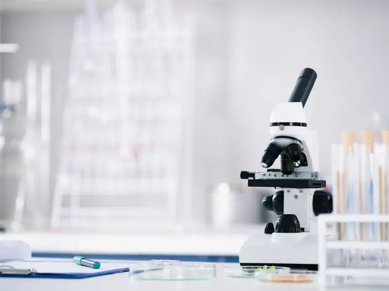 Microscope and lab equipment in a sterile laboratory setting, symbolizing the precision and accuracy of saliva home collection kits for hormone testing.