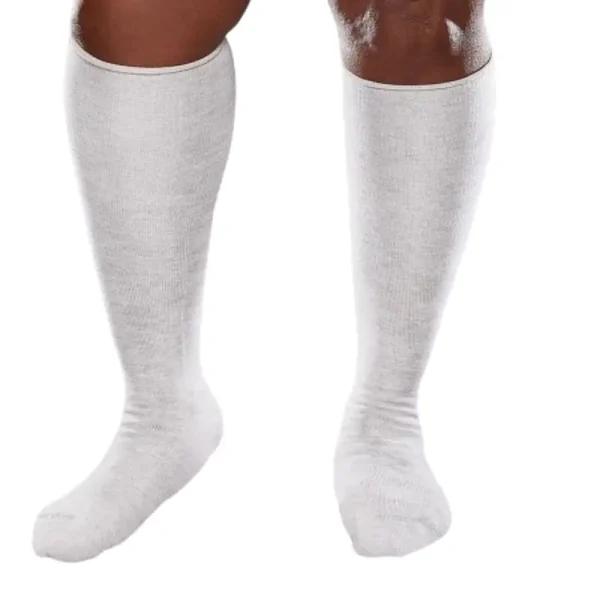 Close-up of a person wearing knee-high, seamless white socks designed for diabetics, offering comfort and support without constricting the legs