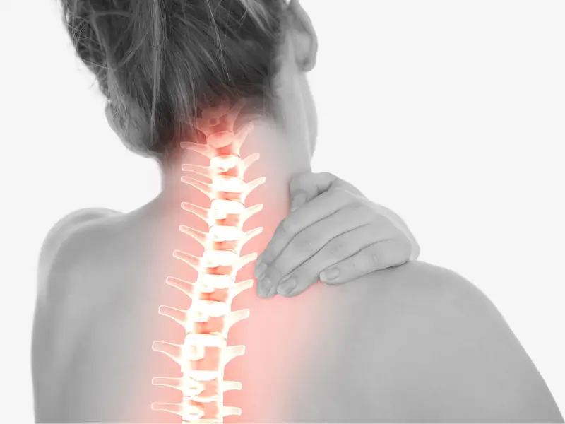 Black and white image of a person from behind holding their neck, with a glowing red illustration highlighting the cervical spine area to denote pain or inflammation.