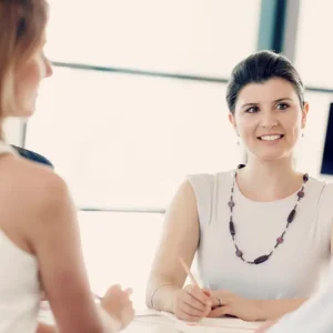 Smiling woman during a naturopathic consultation, focusing on holistic health solutions.