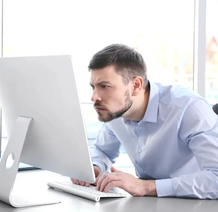 Man experiencing neck pain due to poor posture while using a computer