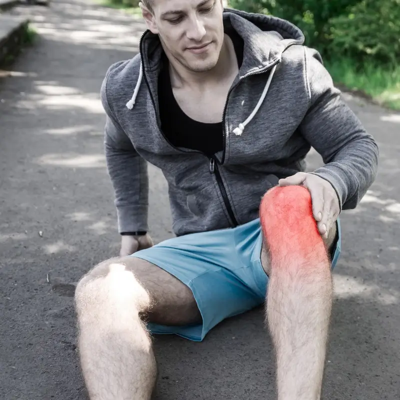 Man holding his knee in pain after running, indicating runner’s knee