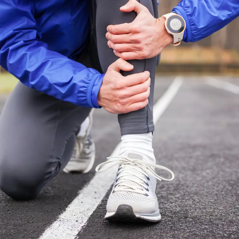 Runner clutching shin due to pain or possible shin splints.