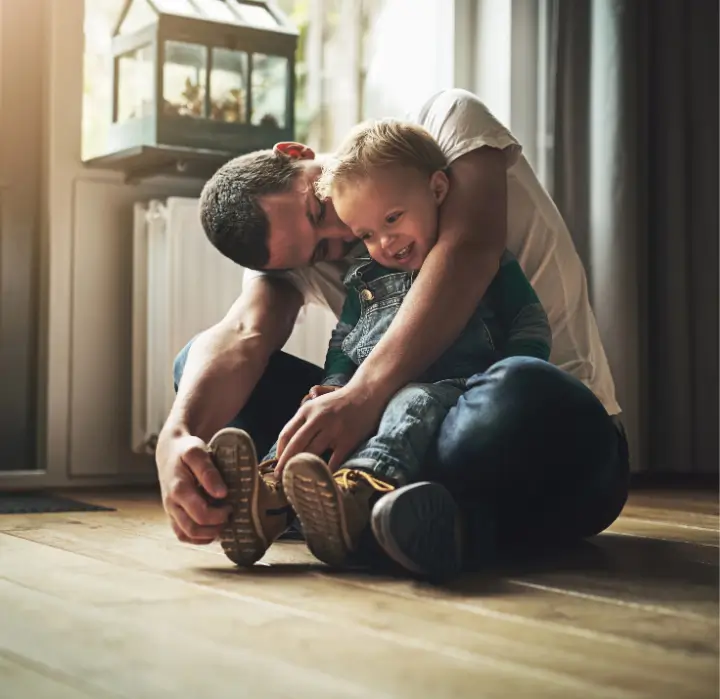 Father recovered from low back pain hugging his son